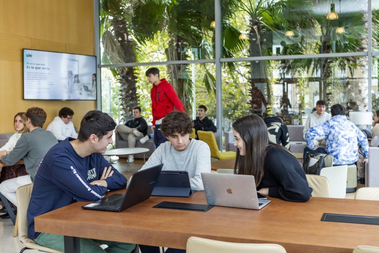 Estudiantes universitarios analizando opciones para elegir máster presencial en la UIE.