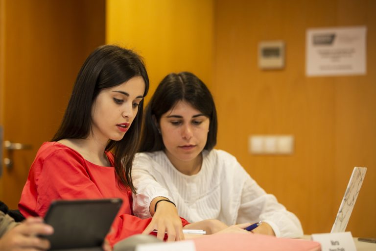 Estudiantes de postgrado en el campus de UIE A Coruña analizando protocolos de ciberseguridad empresarial en Galicia.