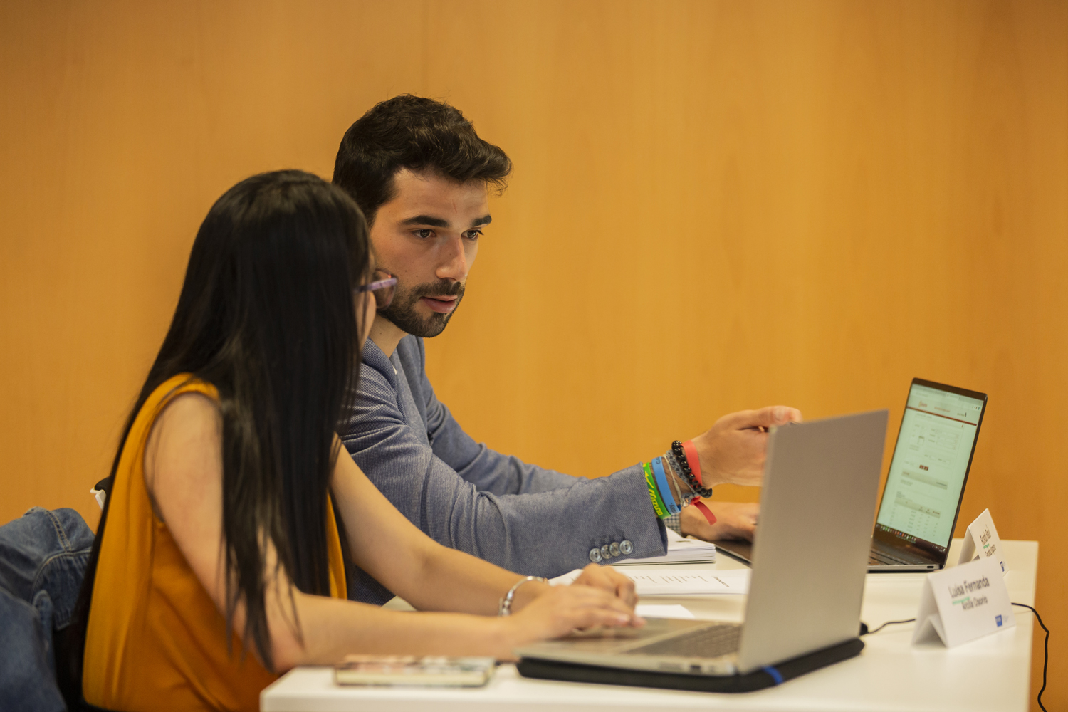 Dos estudiantes de posgrado conversando y analizando oportunidades de empleo en Galicia en el campus de la UIE