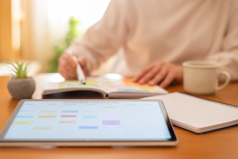 Estudiante organizando su calendario de estudio para la PAU con una tablet y agenda en un entorno universitario moderno